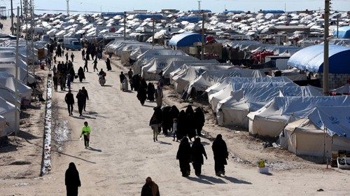 FILE PHOTO: Women walk through al-Hol displacement camp in Hasaka governorate, Syria April 1, 2019. ...