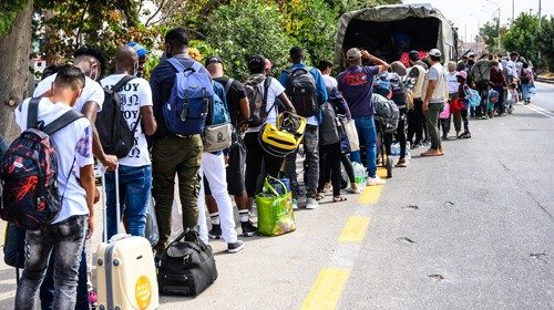 Migranti in attesa di essere condotti al porto di Mytilene a Lesbo (Ansa)