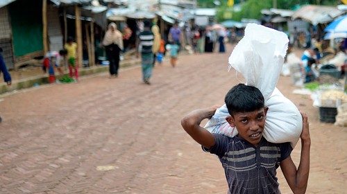 A Rohingya refugee youth carries relief materials at Kutupalong refugee camp, in Ukhia on October 6, ...