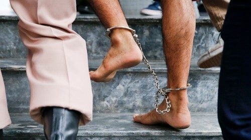 The shackled feet of a bombing suspect in Bangkok, Thailand, are seen as he is escorted by officers ...