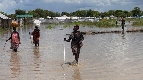 Women wade through flood waters after the River Nile broke the dykes in Pibor, Greater Pibor ...