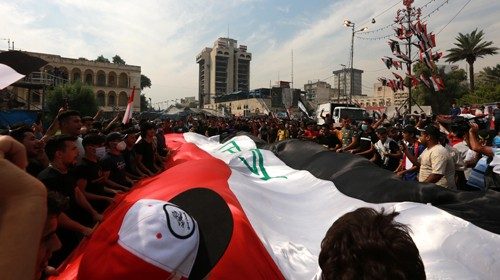 epa08773528 Iraqi protesters carry a national flag as they protest in Baghdad, Iraq, 25 October ...
