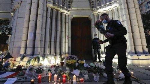 A policeman carries flowers in front of the Notre Dame church in tribute to the victims of a deadly ...