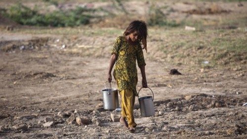On 23 August, a girl carries buckets of water near a camp for people displaced by flooding, in ...
