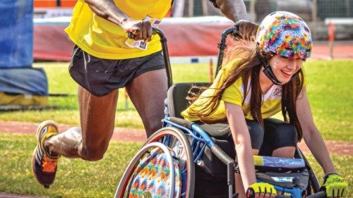 Lo sport è inclusione. Nella foto, due atleti “onorari ” di Athletica Vaticana in azione: a far “c o r re re ” Sara Vargetto, 12 anni, sulla sedia a rotelle è Charles Ampofo, 26 anni. Fuggito dal Ghana, dopo le violenze subite in Libia, è arrivato in Sicilia nel 2014 su un barcone. Oggi ha un lavoro fisso a “Mondo Migliore” grazie alla cooperativa Auxilium (Foto4go)