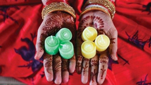 A worker dressed up for 'Karva Chauth' shows candles before packing them for distribution at a ...