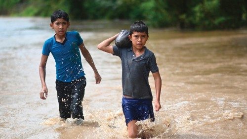Children wade through the water in a flooded area in Panzos, Alta Verapaz, 220 km north of Guatemala ...