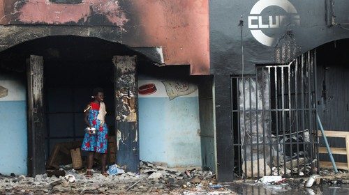 A woman stands near the rubble of a burnt-out store after post electoral inter-community clashes on ...