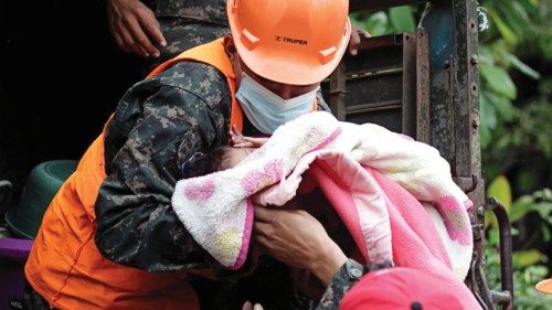 Honduran soldiers hold a baby as they evacuate residents in anticipation of heavy rains as Hurricane ...
