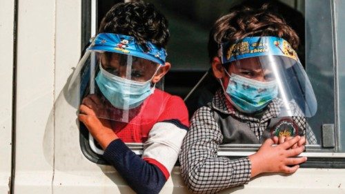 Palestinians school children, clad in masks and face-shields due to the COVID-19 coronavirus ...