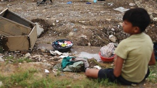A child takes a break from cleaning his house following the flood brought by Typhoon Vamco, in ... A child takes a break from cleaning his house following the flood brought by Typhoon Vamco, in ...