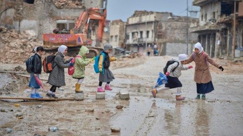 Girls navigate a muddy street Dec. 5 as they make their way to school amid the rubble of the Old ...