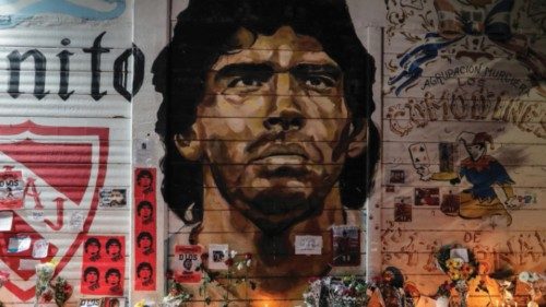 epa08842744 Floral offerings, flags, candles and letters adorn a mural with the image of Diego ...