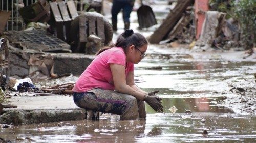 epa08842299 A woman rests after returning to her home to remove the debris due to the floods left by ...