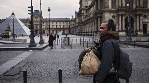 Un senzatetto davanti al museo del Louvre a Parigi Un senzatetto davanti al museo del Louvre a Parigi