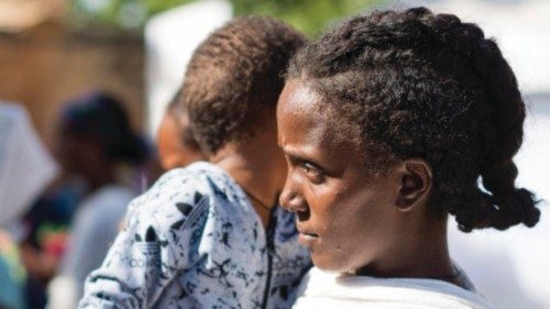 epa08858036 An Ethiopian refugee woman with her child from Tigray region wait to receive aid at the ...