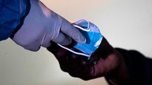 Un volontario distribuisce mascherine ai migranti e ai senza dimora che vivono nei pressi della stazione Tiburtina a Roma (Afp) Un volontario distribuisce mascherine ai migranti e ai senza dimora che vivono nei pressi della stazione Tiburtina a Roma (Afp)