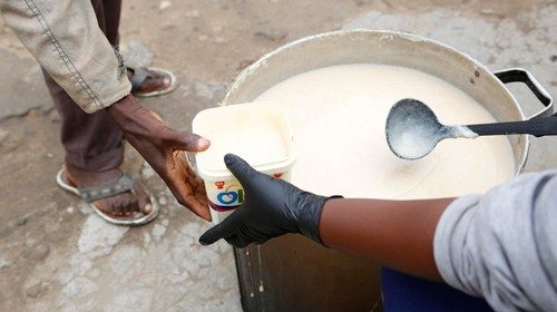 epa08858963 A child receives porridge at Kuchengetana kitchen in Chitungwiza, Zimbabwe, 03 December ...