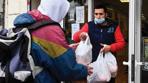 A volunteer gives packs of food to a man at the Noga, a social restaurant in Marseille, on December ...