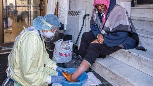 A health care worker in Detroit cares for a homeless man in early May at the Pope Francis Center ...