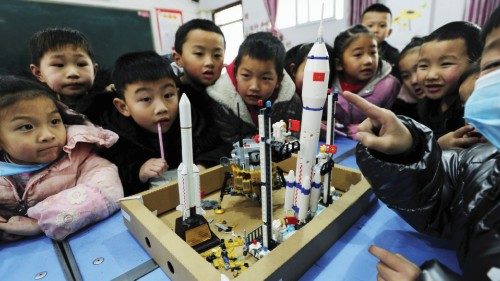 Bambini cinesi osservano il modellino di un razzo lunare (Afp)