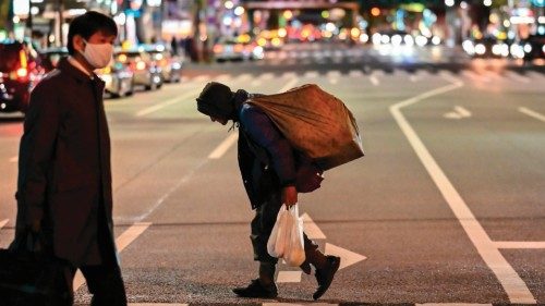 A homeless man (C) carries a bag while crossing a street at night in Tokyo's Shimbashi area on ... A homeless man (C) carries a bag while crossing a street at night in Tokyo's Shimbashi area on ...