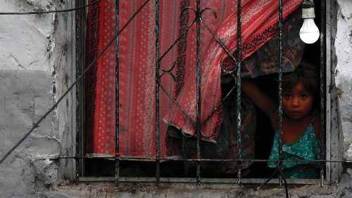 A girl looks from the window of her family's house, during the coronavirus disease (COVID-19) ...