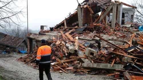 epa08918491 A man walks in front of a destroyed house in the Strasnik village, near Petrinja, 04 ...