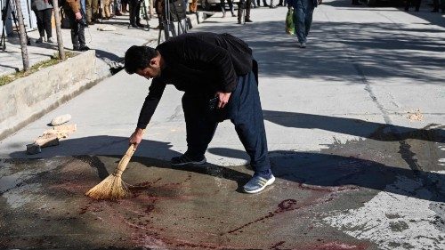A resident washes a road following gunmen shot dead two Afghan women judges working for the Supreme ...