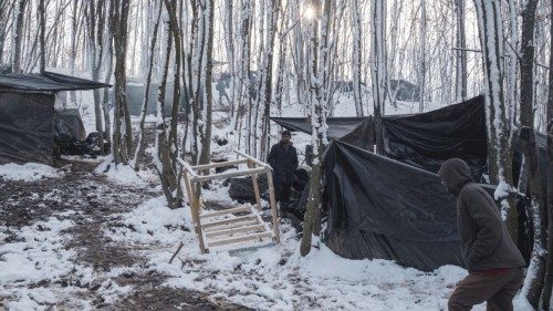 Migrants from Bangladesh stand at the makeshift camp in the woods as hundreds of them are taking ...