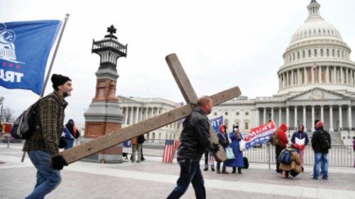 Jeremy LaPointe of Lumberton, Texas (R) carries a cross to a gathering of President Donald Trump ...