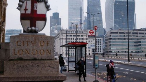 FILE PHOTO: People wearing face masks wait at a bus stop on London Bridge, amid the outbreak of the ...