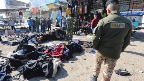 epa08955085 A memeber of Iraqi security forces walks past clothes thrown on the ground at the site ... epa08955085 A memeber of Iraqi security forces walks past clothes thrown on the ground at the site ...