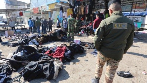 epa08955085 A memeber of Iraqi security forces walks past clothes thrown on the ground at the site ...