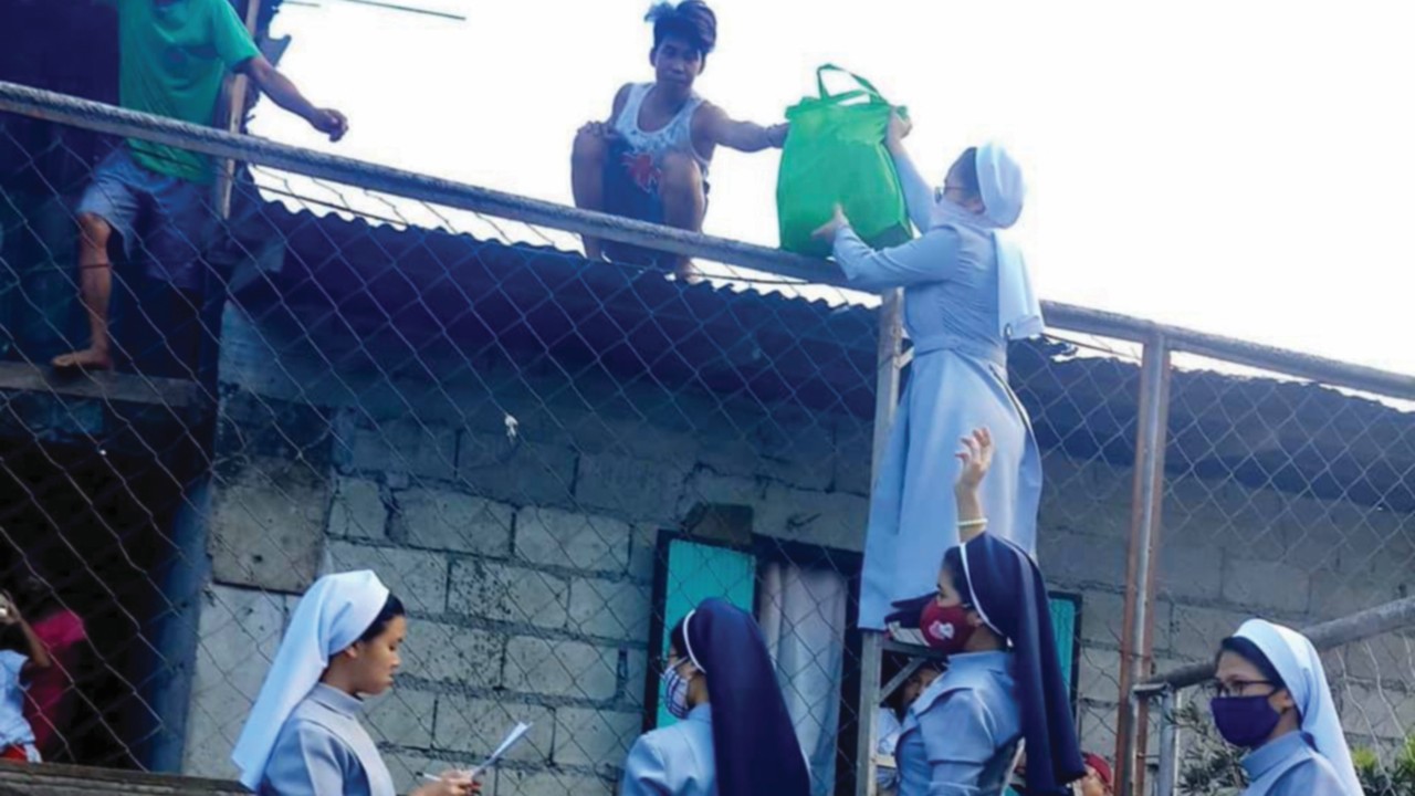 Suore della Carità di San Carlo Borromeo distribuiscono viveri alle famiglie povere della città di Tagaytay, nelle Filippine, durante il lockdown (©CBCP News)