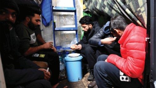 Illegal migrants men from Asia eat their lunch inside their tent, at "Lipa" migrant camp near ...