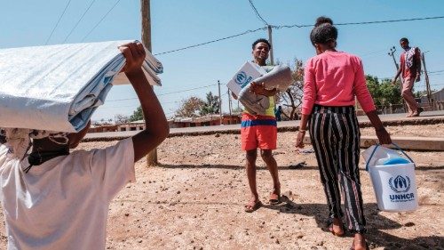 Eritrean refugees walks carrying items during a distribution of items organised the United Nations ...