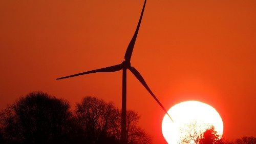 A power-generating windmill turbine is pictured during sunset at a wind park at Bihucourt near ...