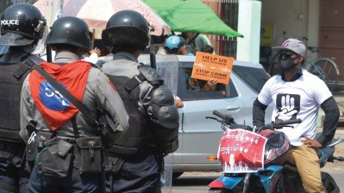 A protester with a bike faces off with riot police standing guard on a road during a demonstration ...