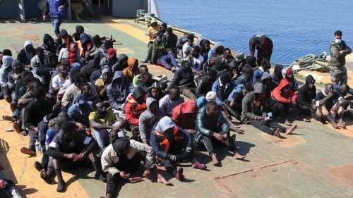 Rescued migrants sit aboard a Libyan coastguard vessel arriving at the capital Tripoli's naval base ...