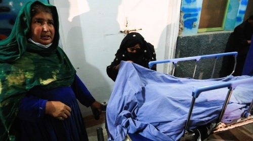 Relatives stand near the body of one of three female media workers who were shot and killed by ...