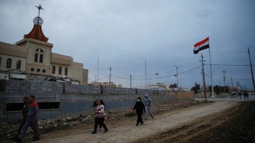 Iraqi Christian walk near a church in Qaraqosh, Iraq February 16, 2021. Picture taken February 16, ...