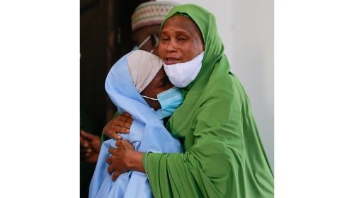 An official embraces a girl who was kidnapped from a boarding school in the northwest Nigerian state ...