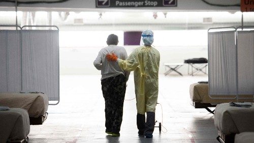 (FILES) In this file photo taken on December 16, 2020 A nurse supports a patient as they walk in the ...