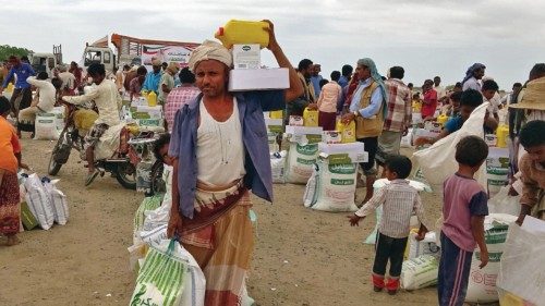 (FILES) In this file photo taken on February 22, 2021 People displaced by conflict receive food aid ...