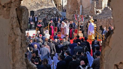 Pope Francis addresses people from the podium at the square near the ruins of the Syriac Catholic ...