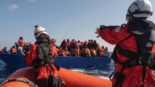 Members of the German charity Sea-Watch 3 rescue ship team help migrants on a wood boat during a ...