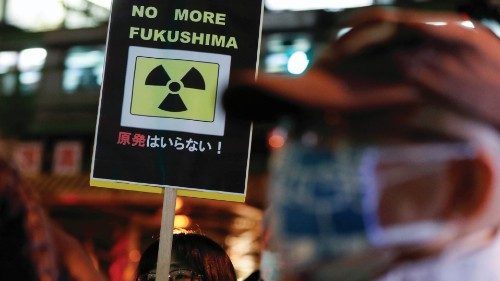 A protester holds a placard during an anti-nuclear rally in front of the headquarters of Tokyo ...