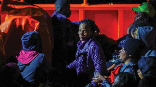 Migrants wait to disembark from a Spanish coast guard vessel, in the port of Arguineguin, in the ...