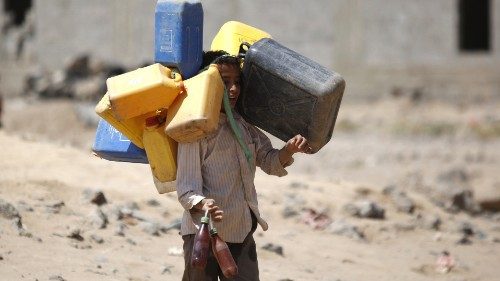 A boy carries buckets to fill with water from a public tap amid an acute shortage of water, on the ...